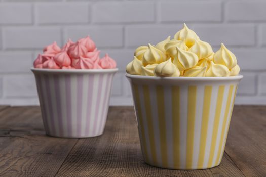 Yellow and pink sweets on wood table