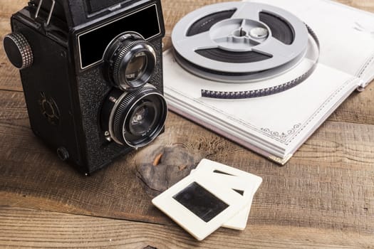 Old Camera With Film Roll and Notebook on Wood Table