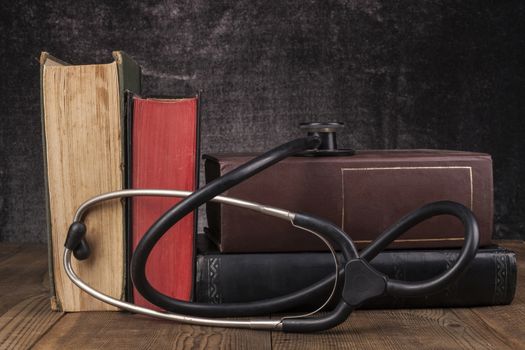 Old Books on Wood Table with Black Stethoscope