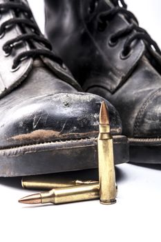 Bullets and army boots isolated on white background with shadow