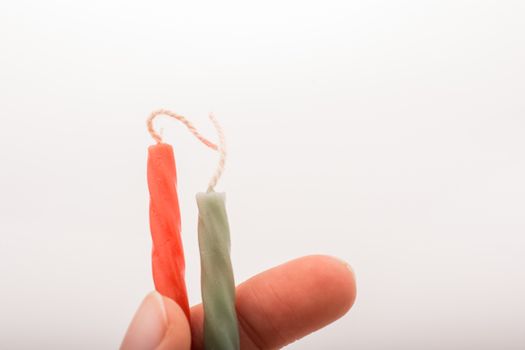 Colorful candle stick in hand on a white background