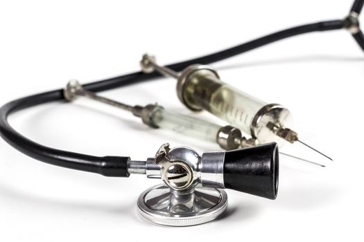 Glass Syringe With Black Old Stethoscope on White Background
