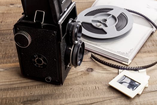 Old Camera With Film Roll and Notebook on Wood Table