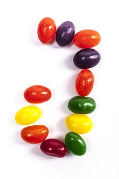 Letter J made from candies isolated on white background with shadow