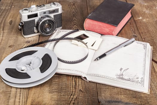 Old Camera With Film Roll and Notebook on Wood Table