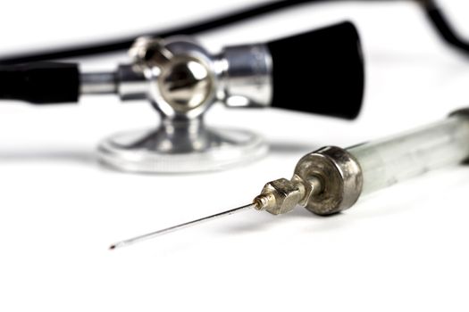 Glass Syringe With Black Old Stethoscope on White Background