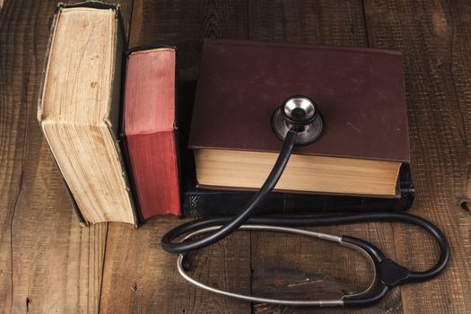 Old Books on Wood Table with Black Stethoscope
