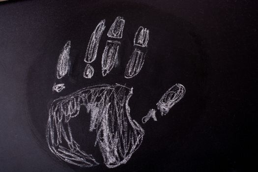 Handprint drawn by  white chalk on a blackboard