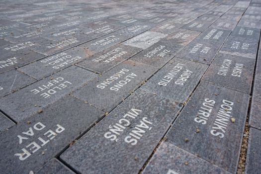Garden of Destinies is a monumental architectural ensemble on the Daugava Island in Koknese. Garden in Koknese. Way with stone slabs with spelled names and surnames.