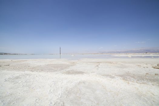 Dead Sea landscape with the jordanian mountains a white salt