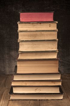 Old Books Pile on Wood Table with Dark Background