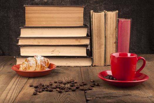 Old Books on Wood Table With Coffee Beans and Croissant