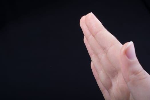 Five fingers of a child hand partly seen in black background