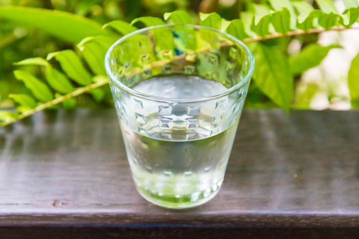 Glass of water, put on the balcony among the nature.