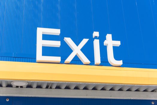 Close-up of outdoor exit sign on building facade