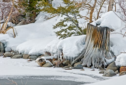 Frozen lake in winter surrounded by snow-covered land.