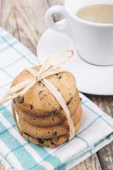 Chocolate chip cookies with coffee on brown wood background