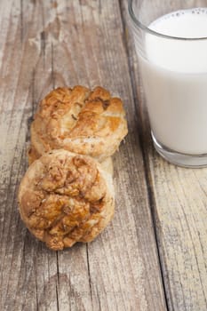 Home made cookies with glass of milk on white wood