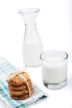 Glass of milk and chocolate chips cookies on white background