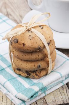 Chocolate chip cookies with coffee on brown wood background