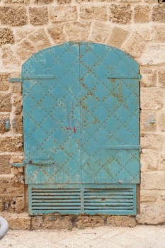 Old rusty iron door on brown stone wall
