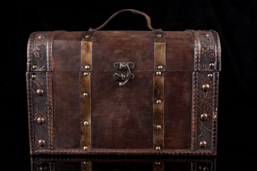 Old wood chest closed isolated on black background with reflection