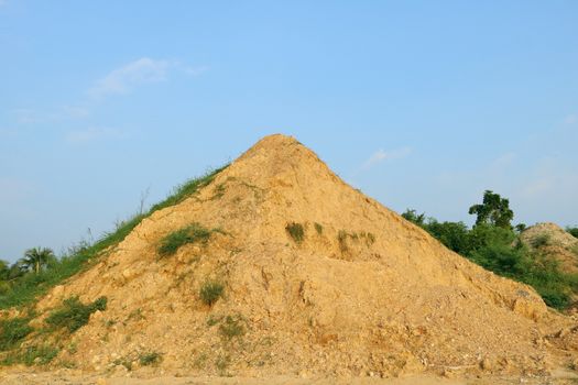 Mountain of sand and clay on the background of blue sky