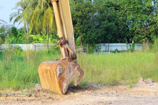 Heavy yellow excavator digging with floor soil.