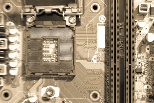Electronic circuit boards on brown background with RAM connector slot and CPU socket, selective focus