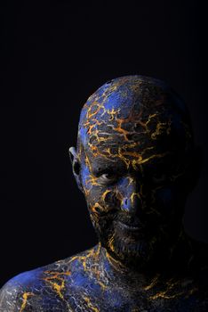 Conceptual Portrait of a brutal man painted in face art style over black background