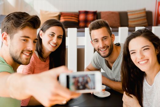 Group of friends at the coffee shop making a selfie together 