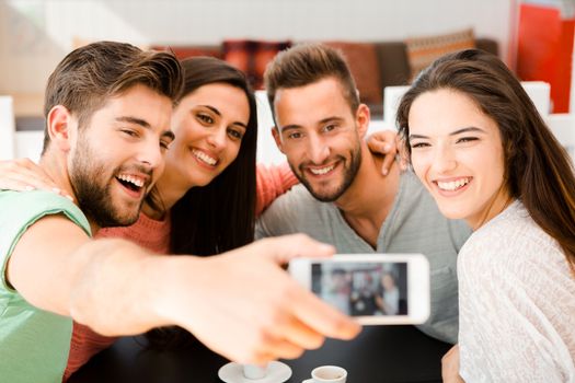 Group of friends at the coffee shop making a selfie together 