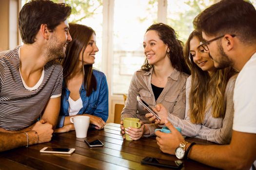 A group of friends talking and drinking coffee at the cafe