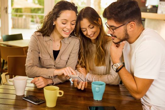 Friends studying together and watching something on the phone