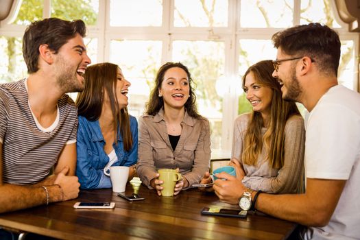 A group of friends talking and drinking coffee at the cafe