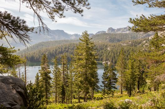 Mountainside with pine trees and lake in the distance in Mammoth Lakes, California