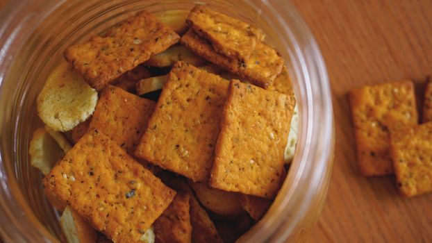 Wheat cracker in a glass jar on wooden table. The concept of kitchen and food