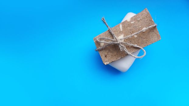 Gray and white Handmade soap wrapped with twine on a blue clean background