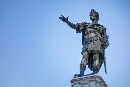 Bronze statue of Emperor Augustus in front of blue sky in Augsburg, Bavaria, Germany
