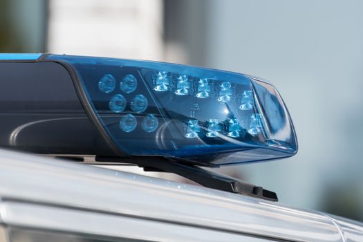 Detail shot of a blue light on a police car on the street