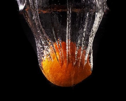 fresh yellow lemon and orange tangerines in water splash on black background