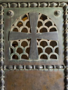 old Rusty metal crucifix with pattern on old church door