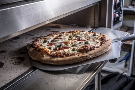 Making Pizza with open oven ready to take out