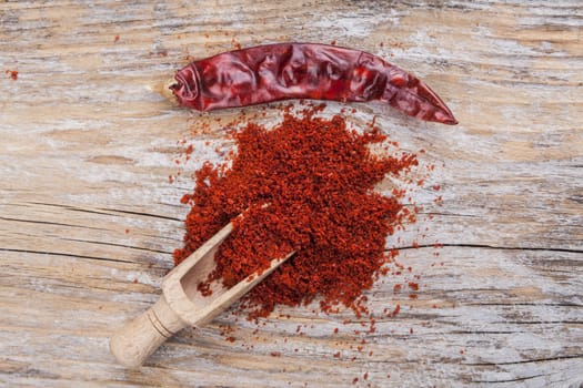 Red hot dry chili pepper and paprika on wood background