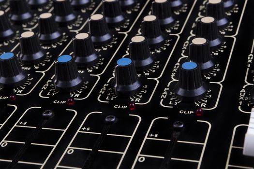 Analog studio sound mixer closeup with colored knobs