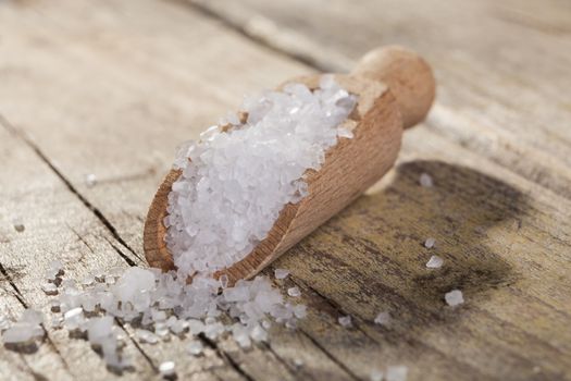 Old Brown wood spoon with salt cristals on wood table