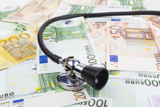 Black stethoscope  on pile of euro banknotes closeup isolated on white background