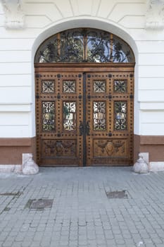 Old brown wood door ornated with black iron 