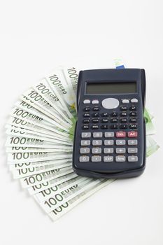 One hundred Euro banknotes with Black calculator isolated on white 