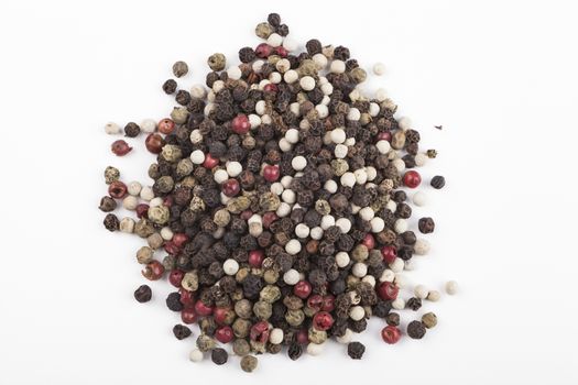 Dry colored pepper types heap  isolated on white background